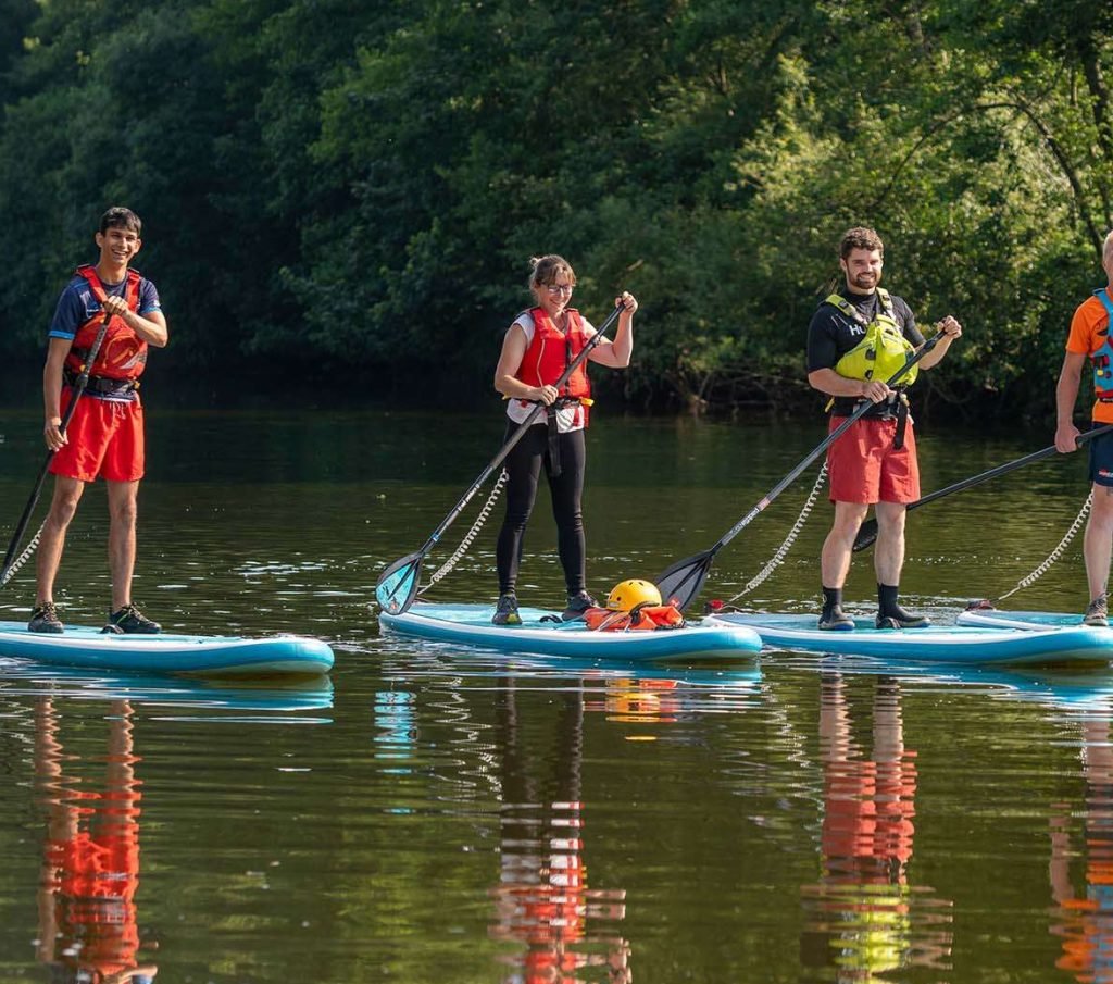 Group of paddlers learning to stand-up paddleboard on the River Wye