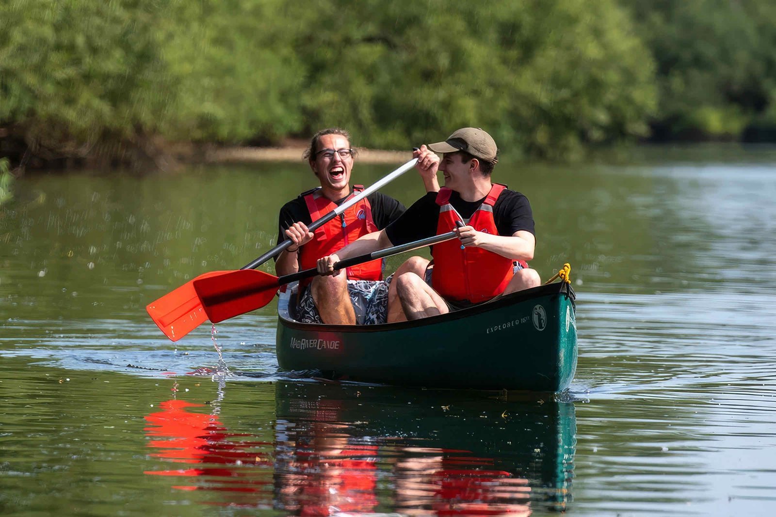 Two paddlers laughing while canoeing on the River Wye near Symonds Yat